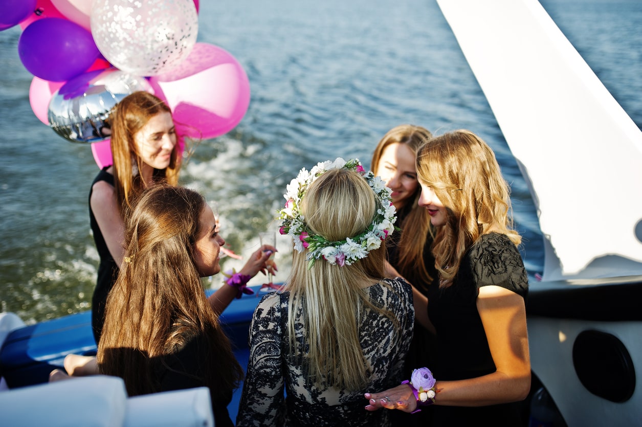 Celebración de despedida de soltera en un yate de lujo en Marbella, amigas brindando con champagne al atardecer